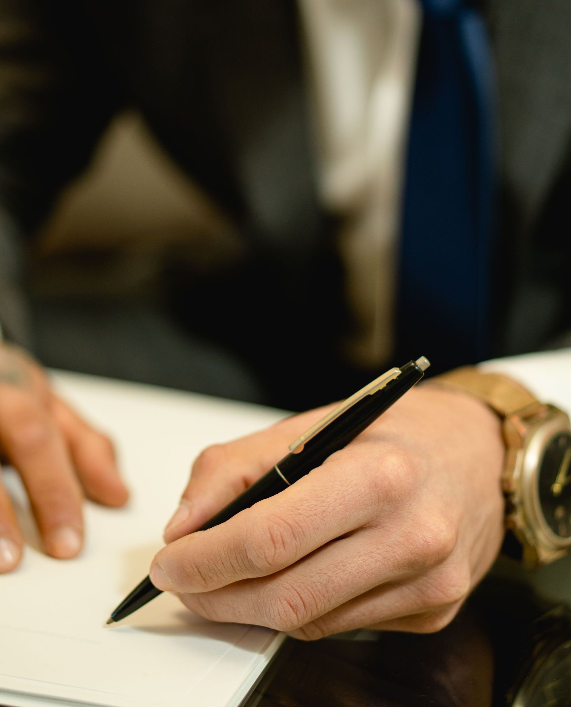 Close-up of hand signing a legal contract with a pen. Ideal for business and legal themes.
